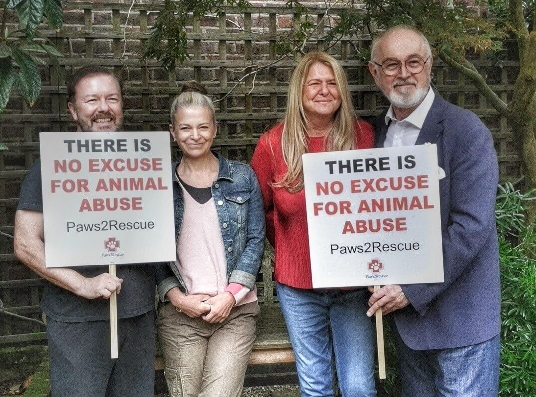 Ricky Gervais with wife Jane Fallon and Peter Egan holding bespoke protest placards for animal rights