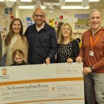 A group of people holding a large foamex cheque