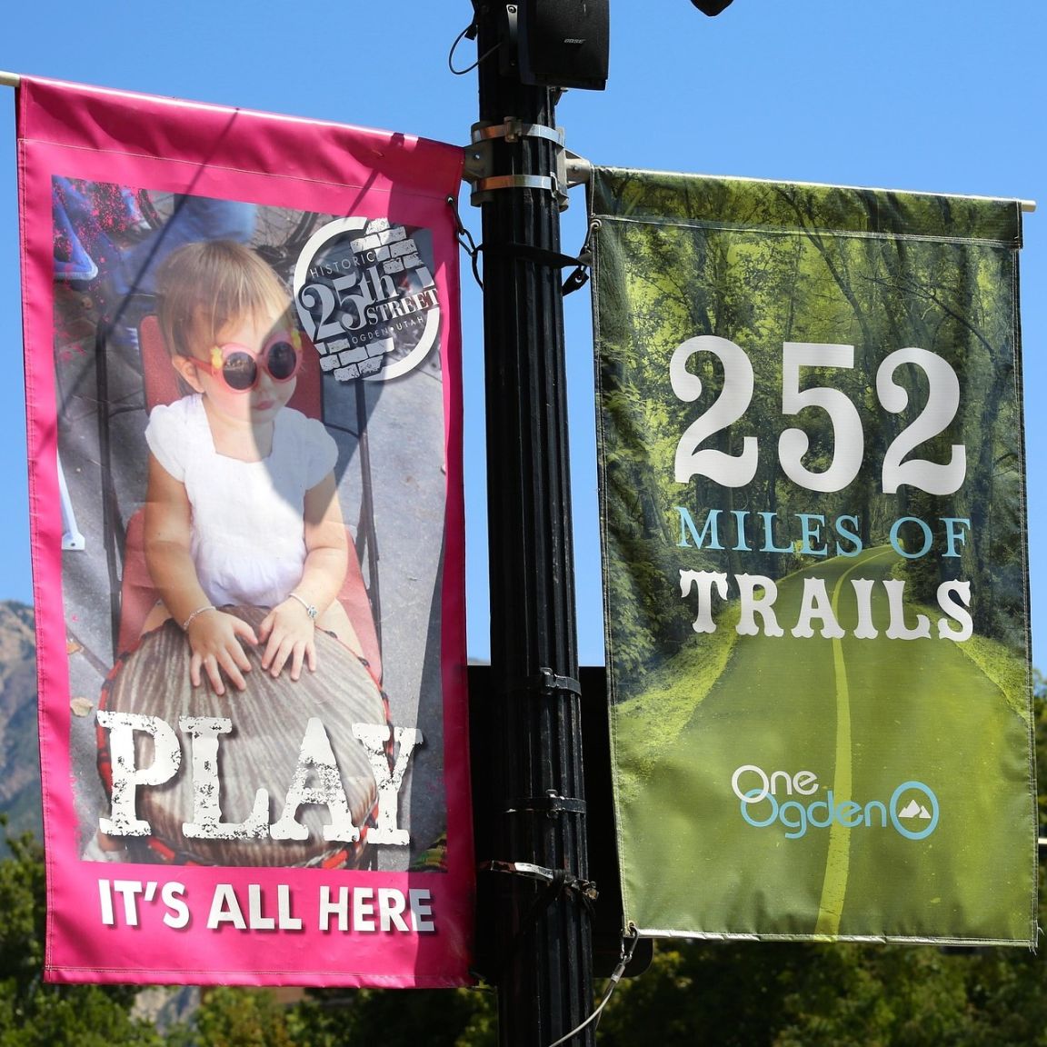 Two outdoor banners hanging side by side with clear imaging and text to catch the eye of potential consumers.