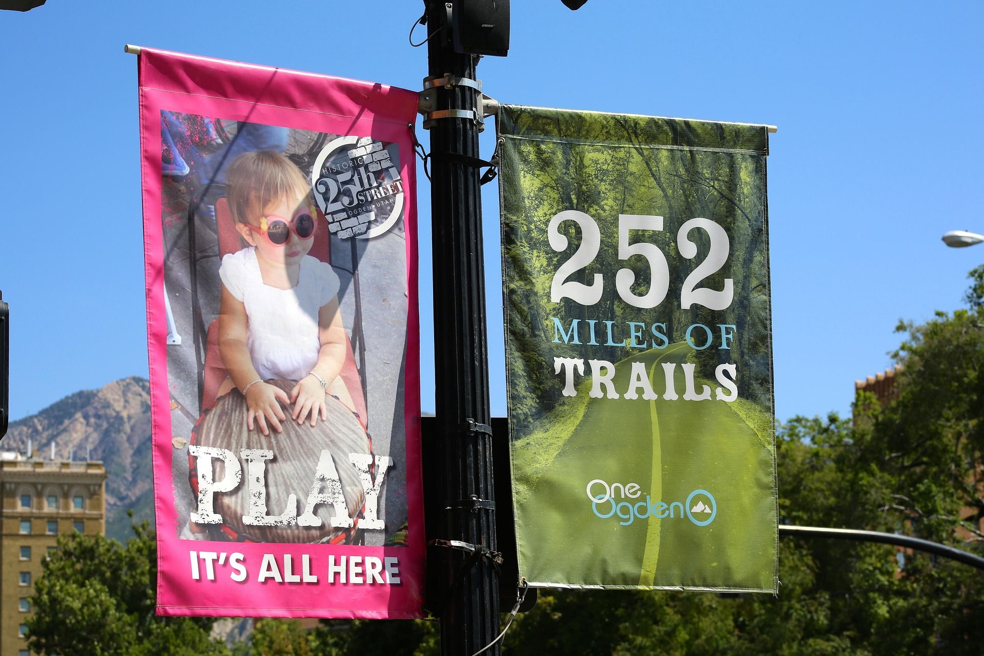 Two outdoor banners hanging side by side with clear imaging and text to catch the eye of potential consumers.